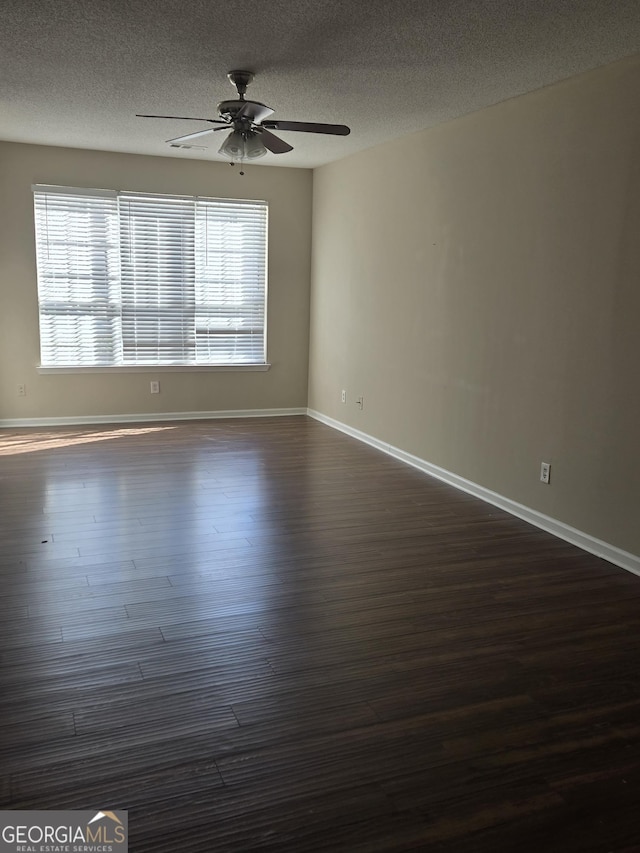 spare room featuring ceiling fan, plenty of natural light, dark hardwood / wood-style floors, and a textured ceiling