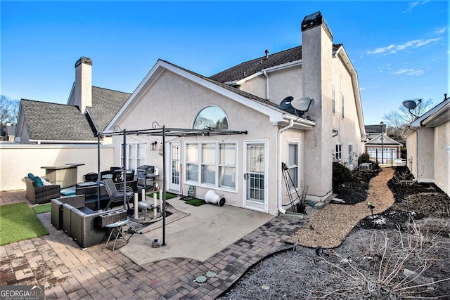 back of property featuring outdoor lounge area, a pergola, and a patio area