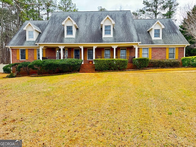 cape cod-style house featuring a front yard and a porch