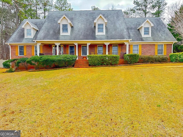 cape cod-style house featuring a front lawn and a porch