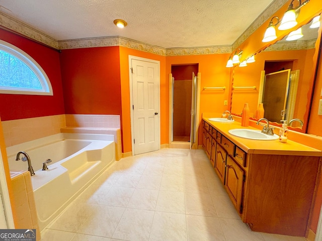 bathroom with tile patterned floors, vanity, shower with separate bathtub, and a textured ceiling