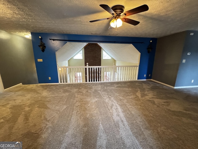 spare room with lofted ceiling, ceiling fan, carpet floors, and a textured ceiling