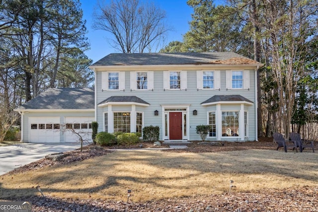 colonial inspired home with a front yard and a garage