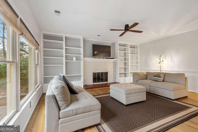 living room featuring a fireplace, hardwood / wood-style flooring, and ceiling fan