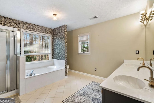 full bathroom with toilet, a textured ceiling, independent shower and bath, tile patterned floors, and vanity