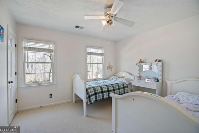 carpeted bedroom featuring ceiling fan and a textured ceiling