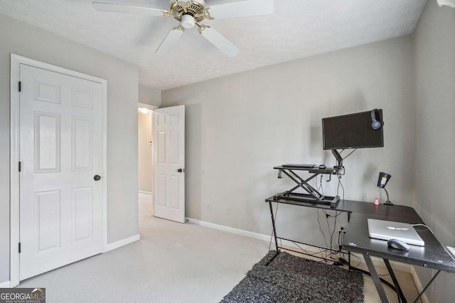 carpeted office space featuring ceiling fan