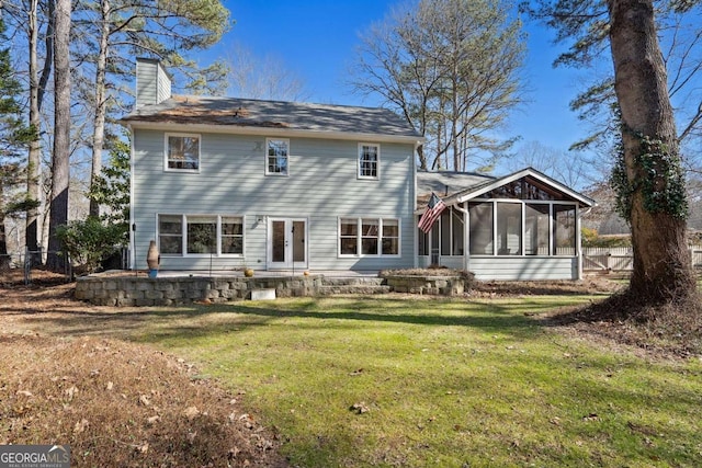 rear view of property with a sunroom and a lawn