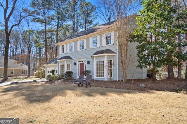 colonial inspired home featuring a front lawn