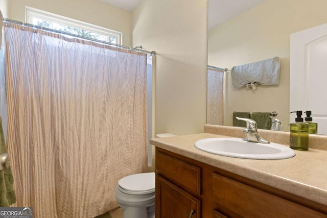 bathroom featuring vanity, toilet, and a shower with shower curtain