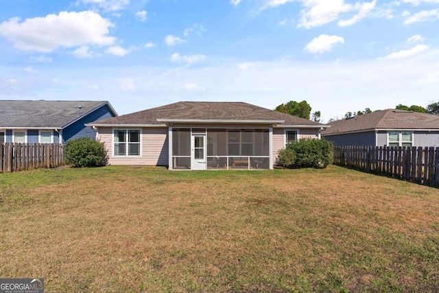 rear view of house featuring a sunroom and a yard