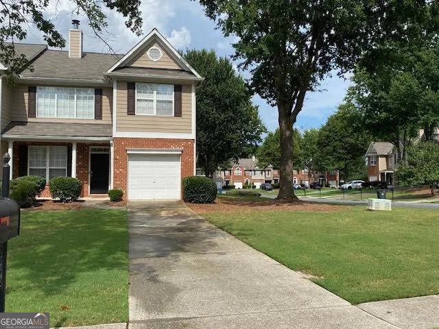 view of front of house featuring brick siding, driveway, and a front lawn