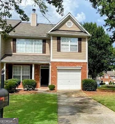 view of front of property featuring a garage, brick siding, driveway, a front lawn, and a chimney