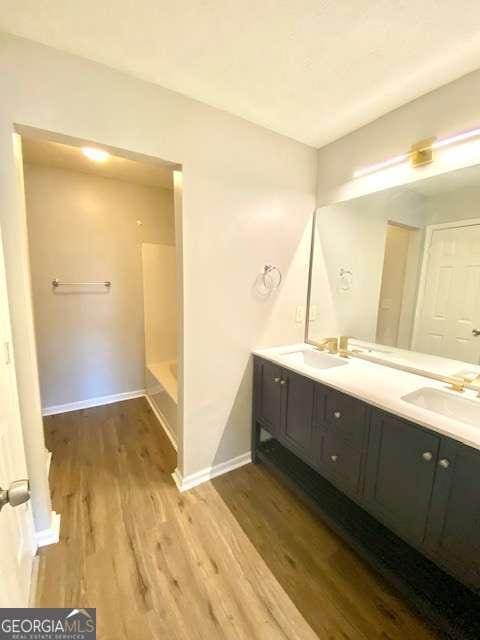 bathroom with wood-type flooring, vanity, and walk in shower