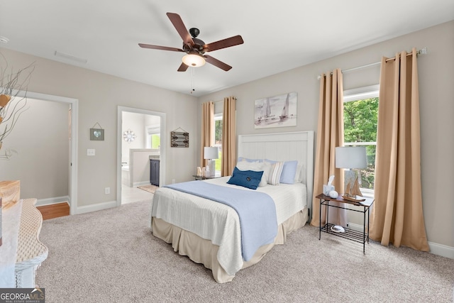 carpeted bedroom featuring ceiling fan and ensuite bath