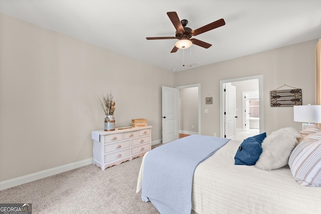 bedroom with ceiling fan, ensuite bathroom, and light carpet