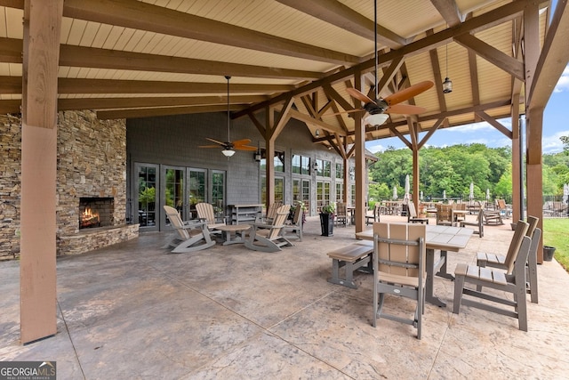 view of patio featuring ceiling fan and an outdoor stone fireplace