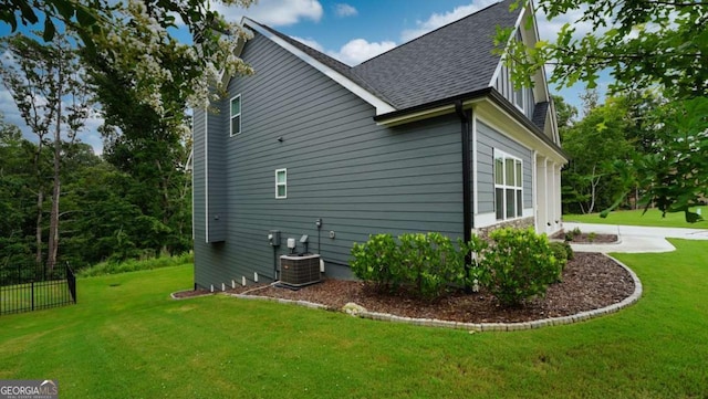 view of side of property with a yard and central AC unit