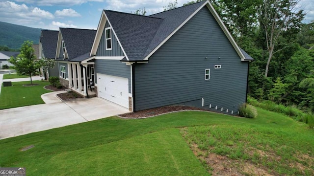 view of side of property with a yard and a garage