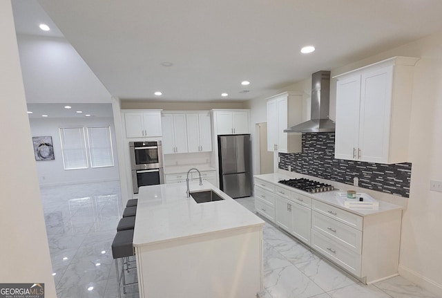 kitchen featuring white cabinetry, wall chimney exhaust hood, stainless steel appliances, and sink