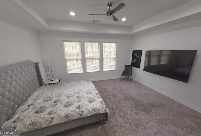 bedroom featuring ceiling fan, a raised ceiling, and carpet floors