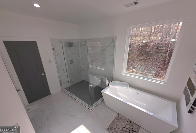 bathroom featuring shower with separate bathtub