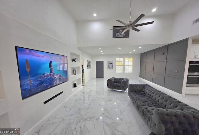 living room with a high ceiling and ceiling fan