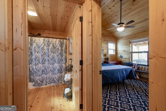 bedroom with vaulted ceiling, hardwood / wood-style floors, wood ceiling, and wood walls