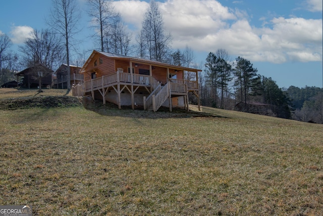 rear view of property with a deck and a lawn