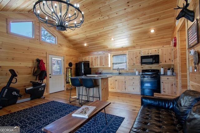 kitchen featuring light brown cabinetry, sink, a center island, light hardwood / wood-style floors, and black appliances