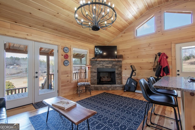 living room with wooden ceiling, light wood-type flooring, a fireplace, and wooden walls