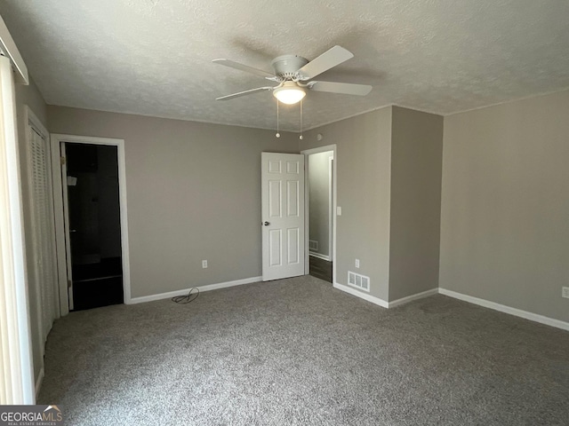 unfurnished bedroom with ceiling fan, carpet floors, and a textured ceiling