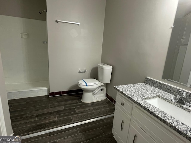 bathroom featuring walk in shower, vanity, and toilet