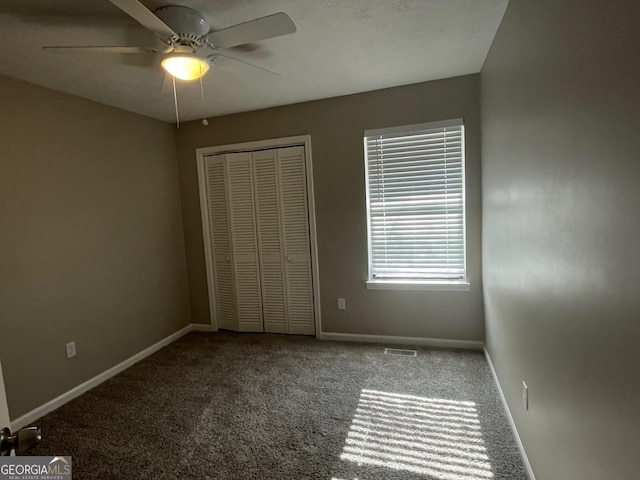 unfurnished bedroom with ceiling fan, carpet flooring, and a closet