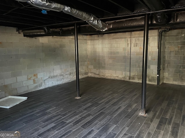 basement with dark hardwood / wood-style flooring