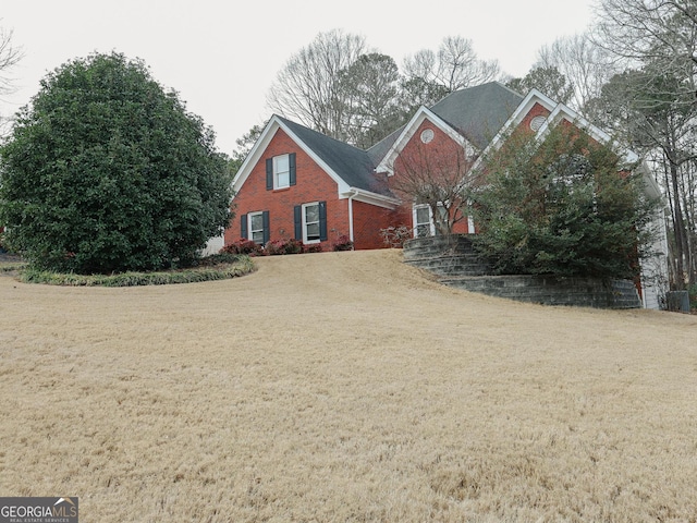 view of front facade with a front yard and brick siding