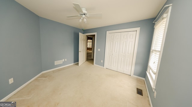 unfurnished bedroom with light colored carpet, baseboards, visible vents, and a closet