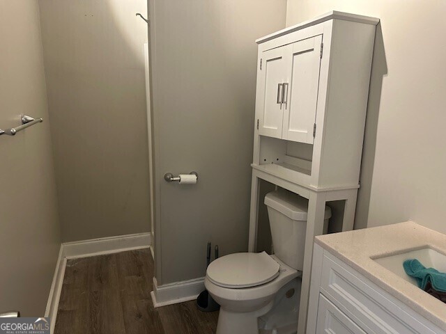 bathroom featuring vanity, hardwood / wood-style flooring, and toilet