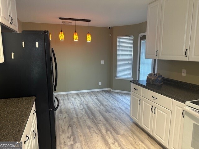 kitchen with white cabinetry, black fridge, hanging light fixtures, light hardwood / wood-style flooring, and white range with electric cooktop