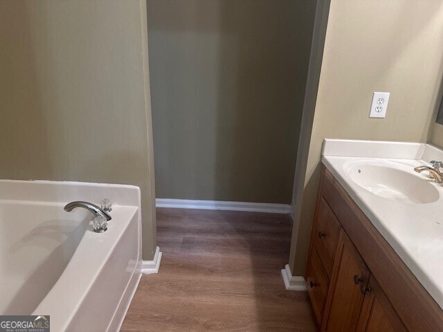 bathroom with vanity, hardwood / wood-style floors, and a washtub