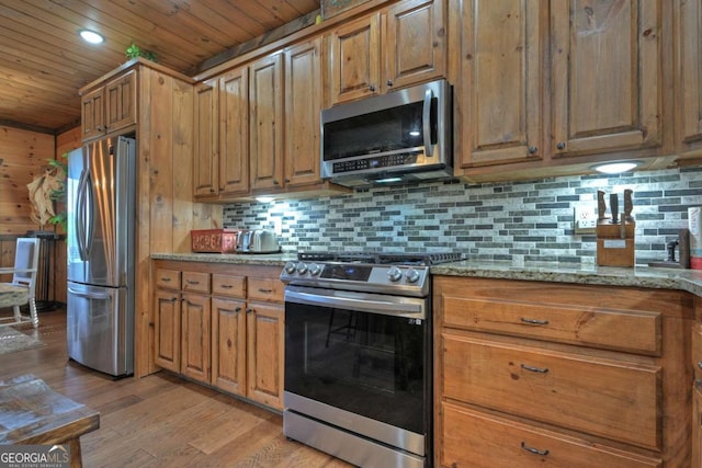 kitchen with light stone counters, wood ceiling, appliances with stainless steel finishes, and light wood-type flooring