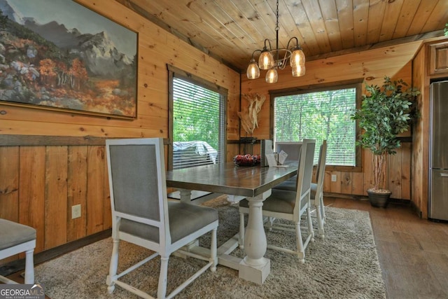 dining area featuring wooden walls, wooden ceiling, and a healthy amount of sunlight