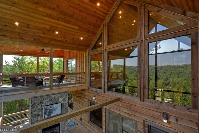 sunroom / solarium with lofted ceiling, wooden ceiling, and ceiling fan