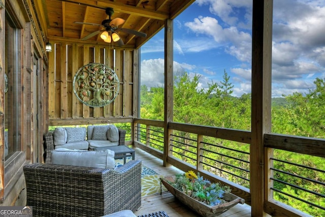 sunroom featuring wood ceiling, beamed ceiling, and ceiling fan