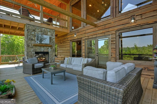 wooden terrace with an outdoor living space with a fireplace