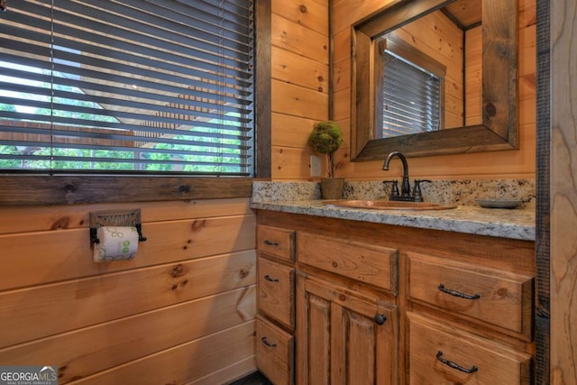 bathroom with vanity and wood walls