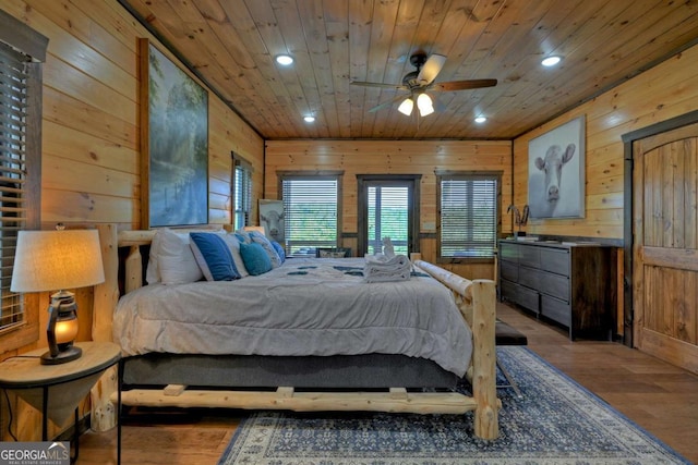 bedroom with hardwood / wood-style floors, wooden ceiling, and wood walls