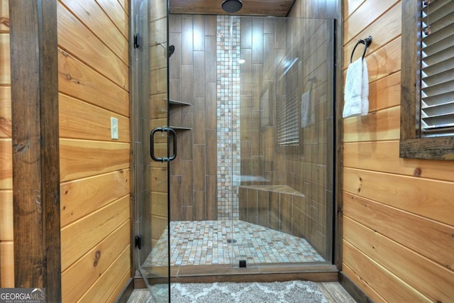 bathroom with a shower with door and wooden walls