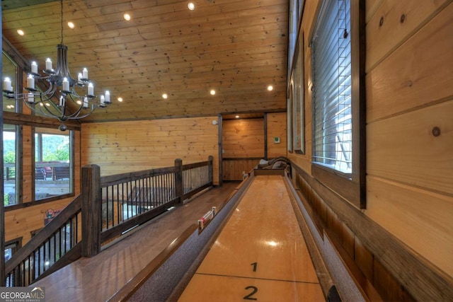 playroom with an inviting chandelier, wood ceiling, and wood walls