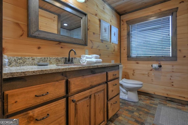 bathroom featuring vanity, wooden ceiling, toilet, and wood walls